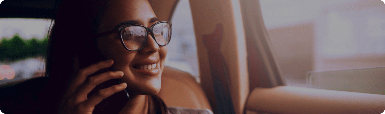mujer de lentes sonriendo mientras habla por celular