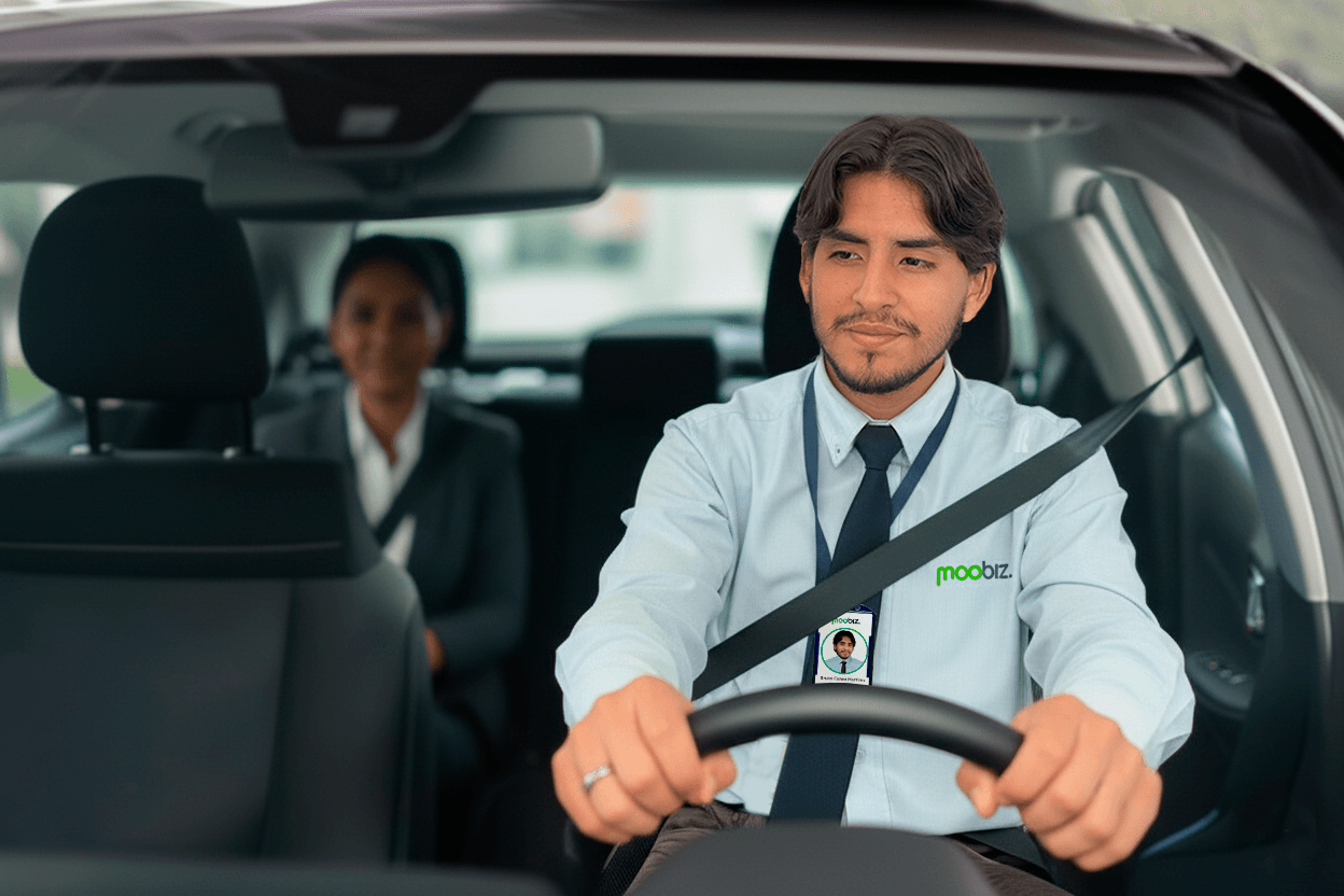 Conductor Moobiz de taxi seguro y profesional en Perú sonriendo al volante. Pasajera ejecutiva en el asiento trasero. Taxi formal y confiable